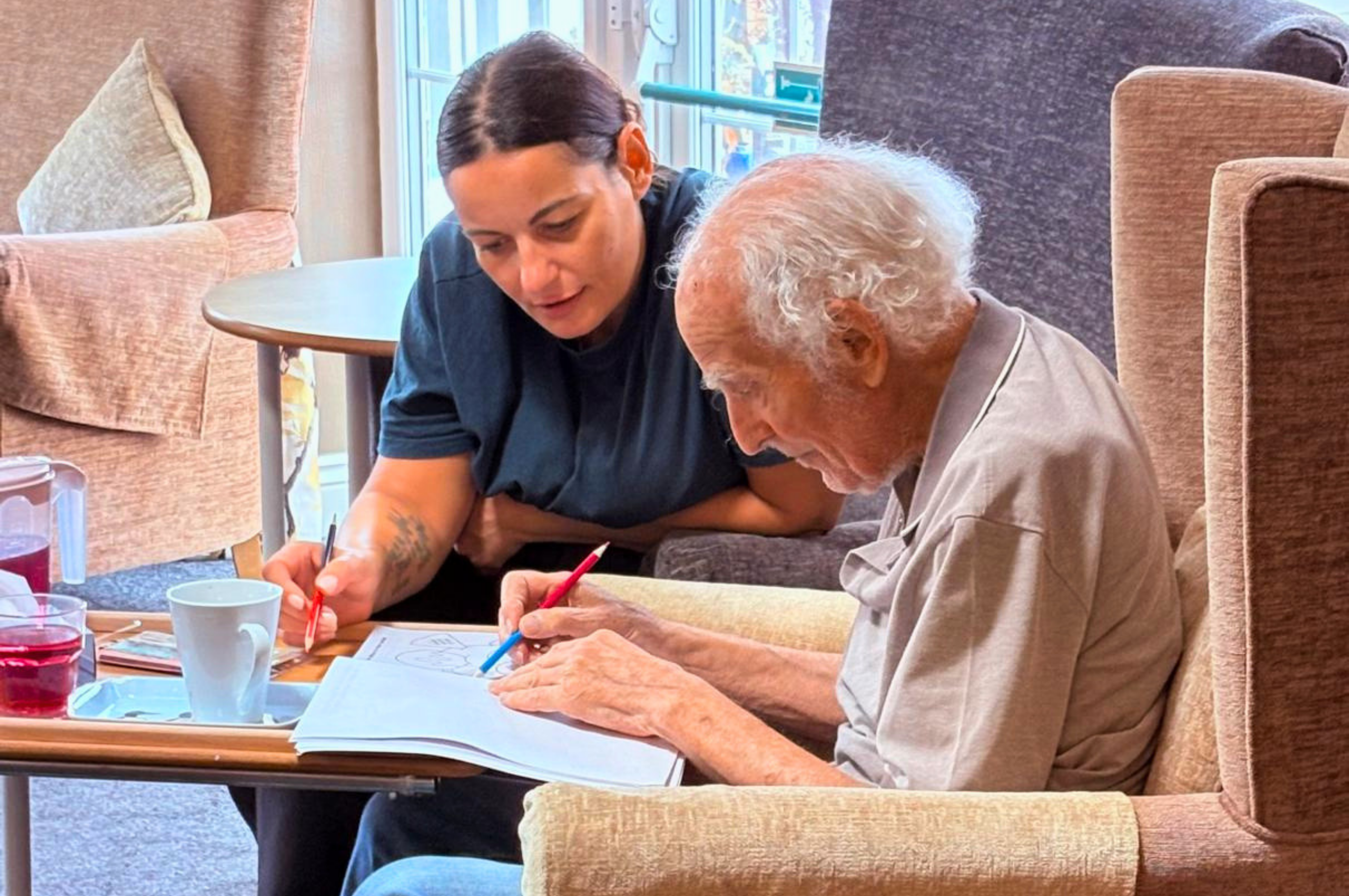 Carer helps resident with activity at Evesham Care Home